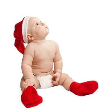 Baby looking up wearing Christmas hat